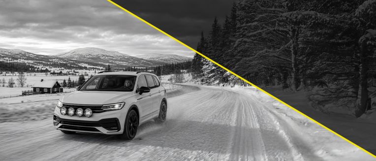 Dunlop Winter Snow1 reklāmas attēls: balts apvidus auto brauc pa sniegotu lauku ceļu kalnu un egļu meža fonā