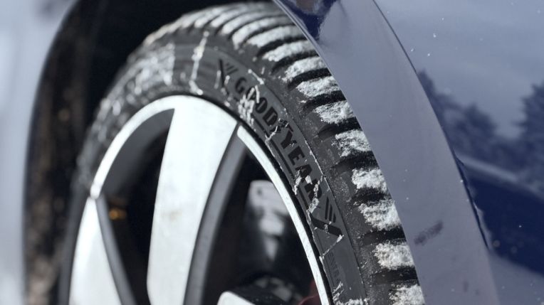 Протектор Goodyear Vector All Season 4 со снегом в канавках на тёмно-синем автомобиле зимой
